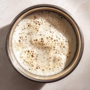Top-down shot of a foamy, activated yeast mixture in a metal bowl